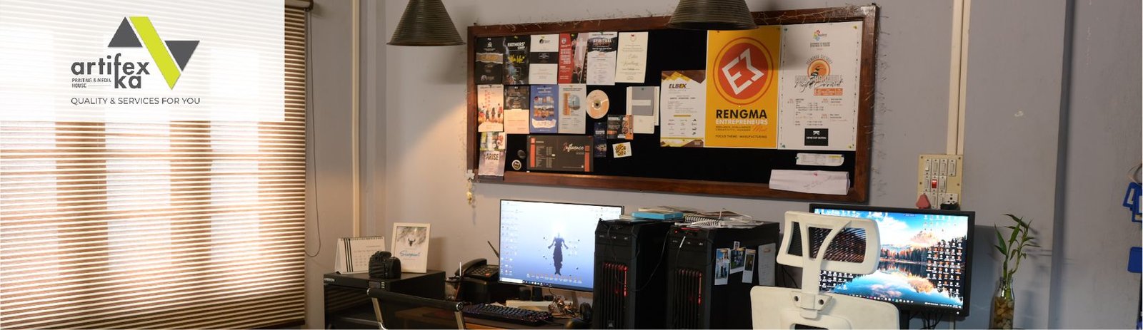The Artifex Ka studio with a pinboard of printed work and two workstations