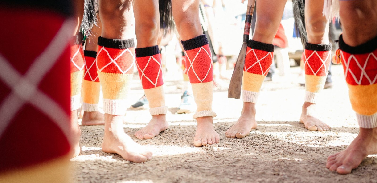 Dancers in traditional Naga dress standing in a circle, seen from ground level