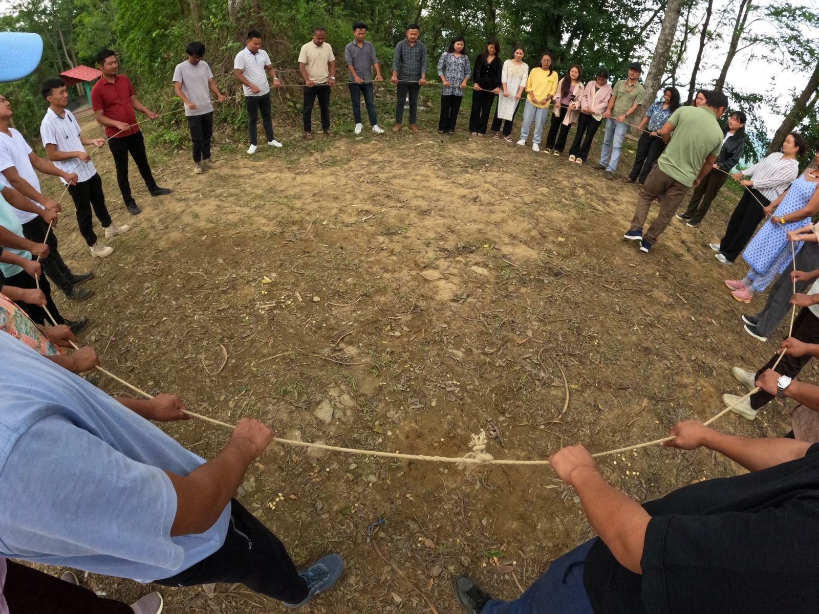 Youth leaders standing in a circle holding a single rope