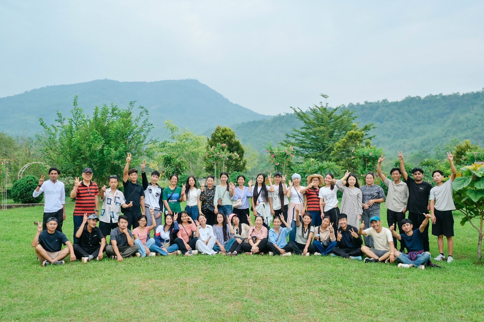 The Kenono team and cooperative members gathered on a lawn below forested hills